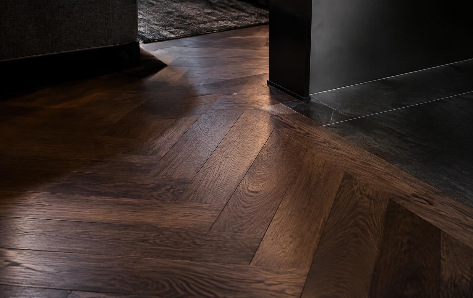 Herringbone hardwood floor transitioning to dark stone tile in Bend, Oregon